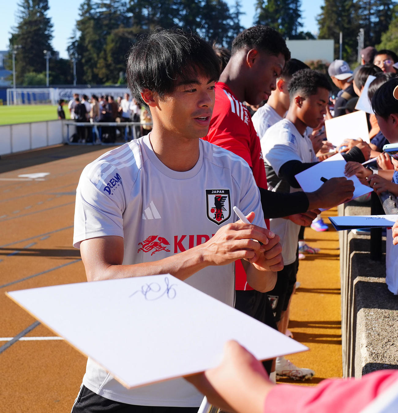 練習後に子どもたちにサインを行う三笘ら日本代表の選手たち（撮影・垰建太）