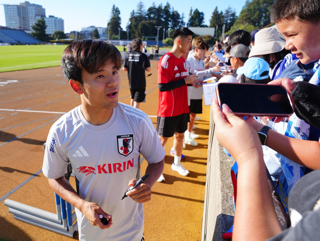 練習後に子どもたちにサインする久保（左）ら日本代表の選手たち（撮影・垰建太）
