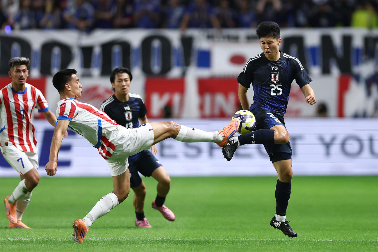 日本対パラグアイ　前半、競り合う鈴木淳（右）（撮影・前田充）