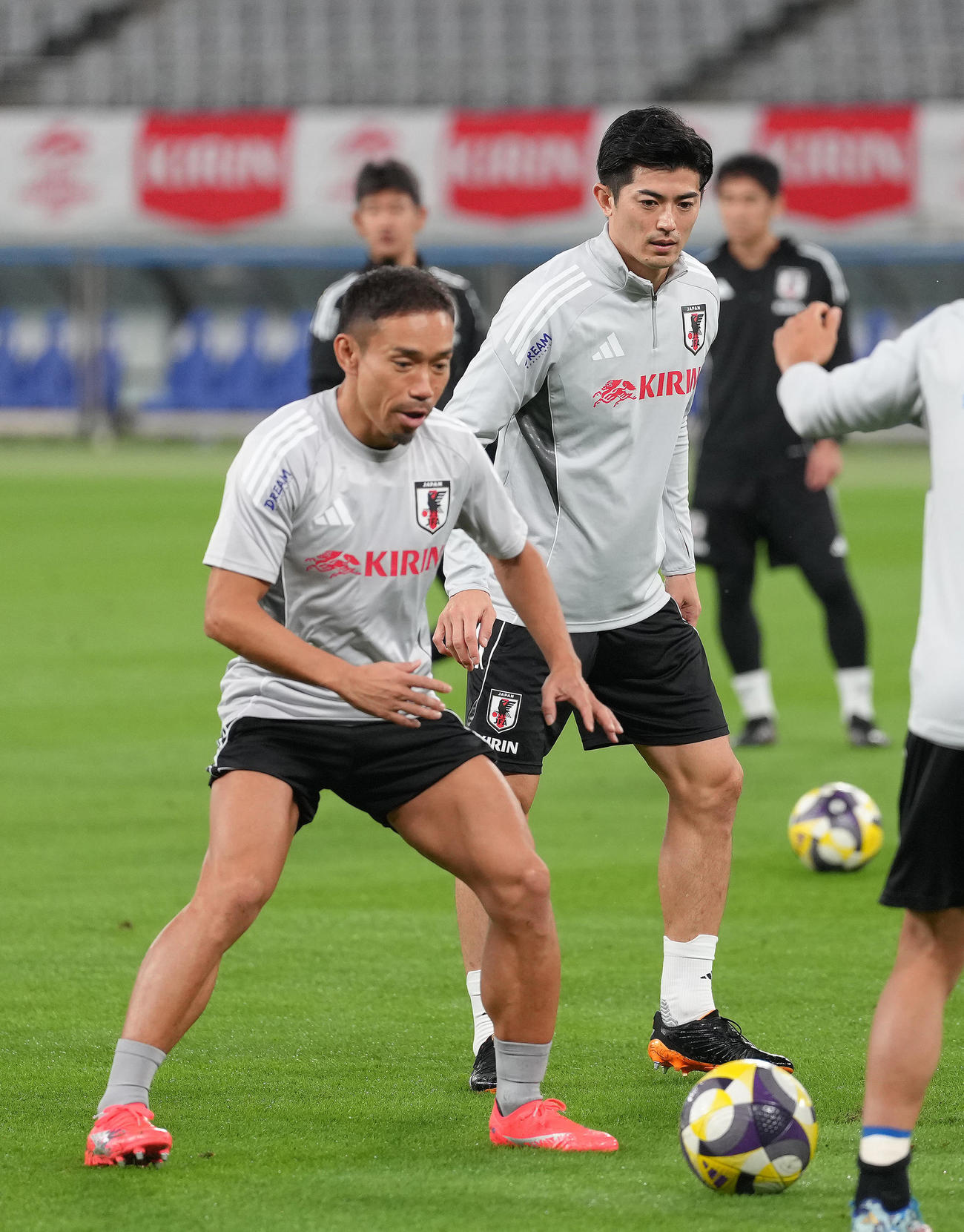 公式練習でボールを追う長友（左）と谷口（撮影・足立雅史）