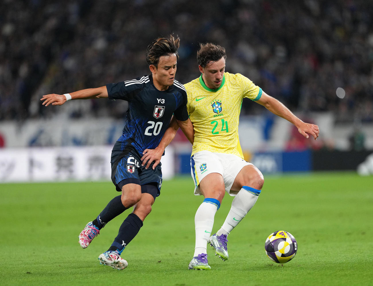 日本対ブラジル　前半、アウグスト（右）のボールを奪いにいく久保（撮影・足立雅史）