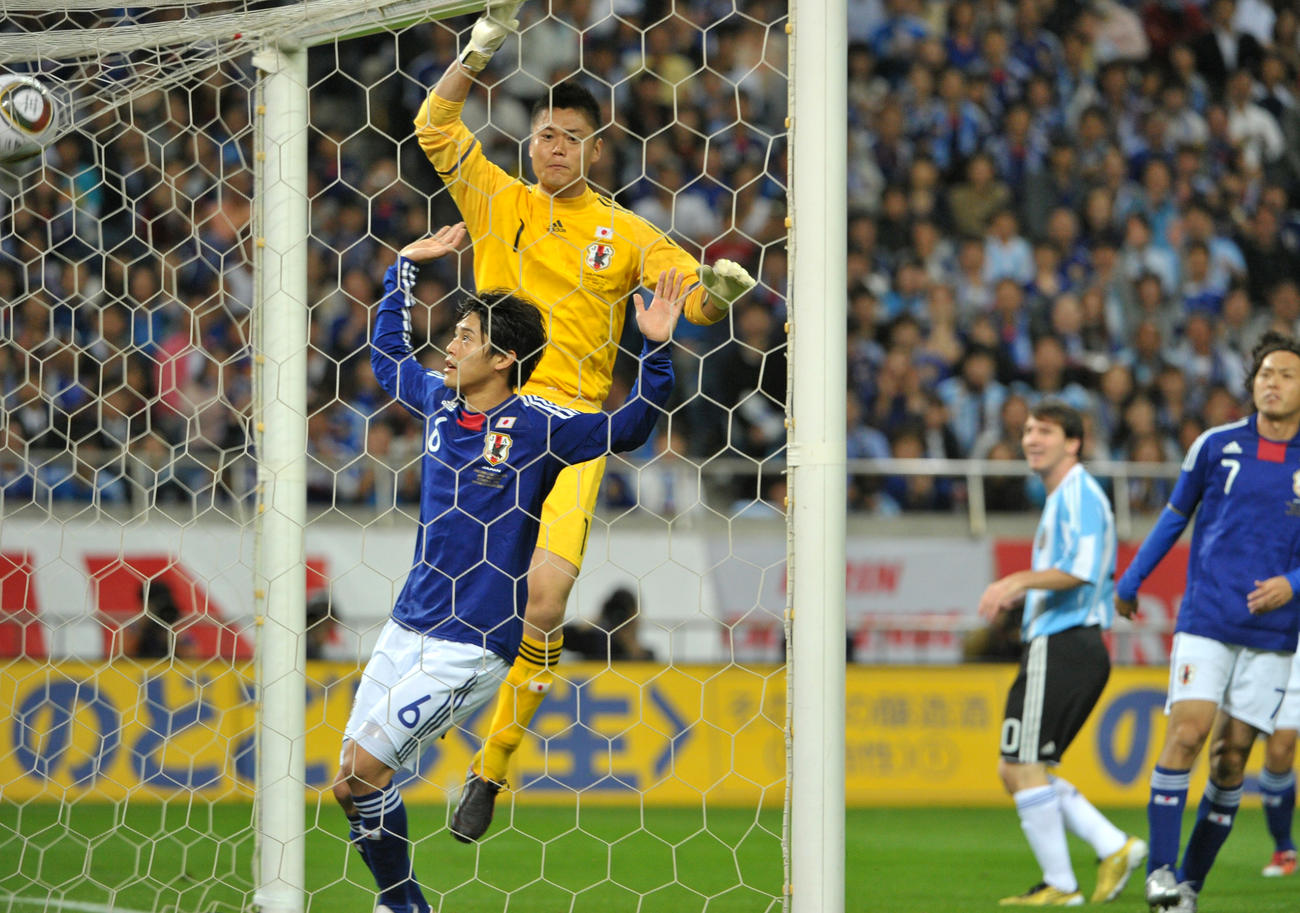 キリンチャレンジカップ2010　日本対アルゼンチン　前半、アルゼンチンFWリオネル・メッシのシュートを阻むGK川島永嗣。左はDF内田篤人（2010年10月撮影）