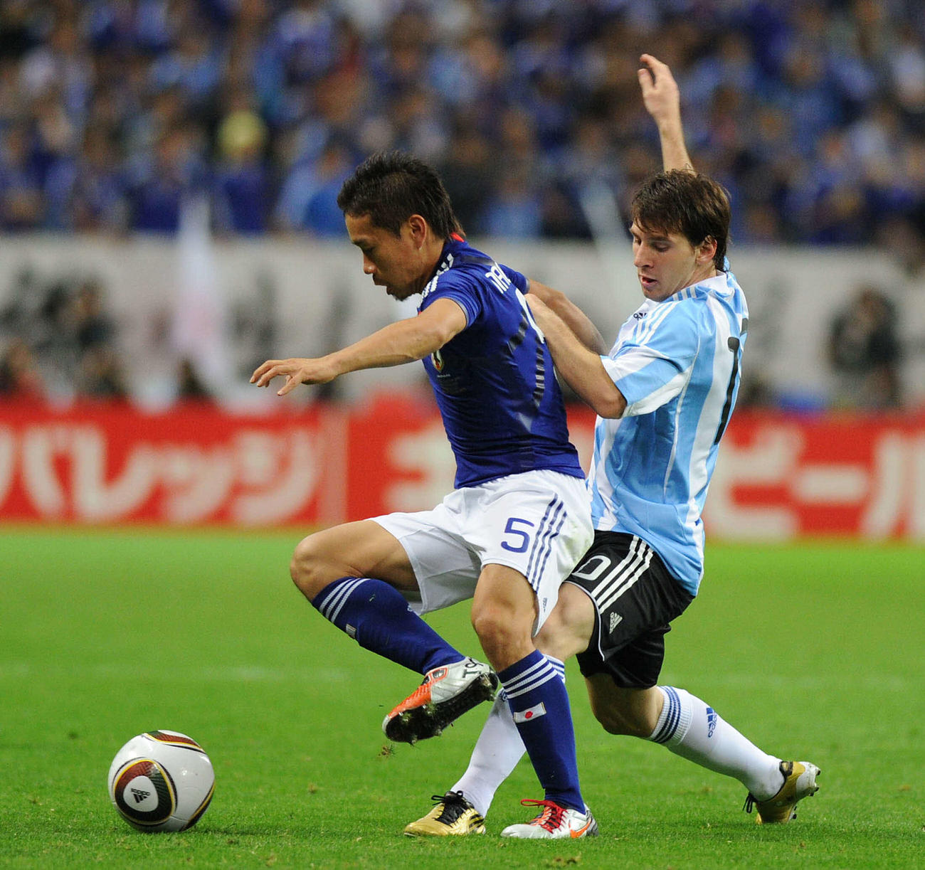 キリンチャレンジカップ2010　日本対アルゼンチン　後半、アルゼンチン代表FWリオネル・メッシ（右）のボールを奪うサッカー日本代表DF長友佑都＝2010年10月8日