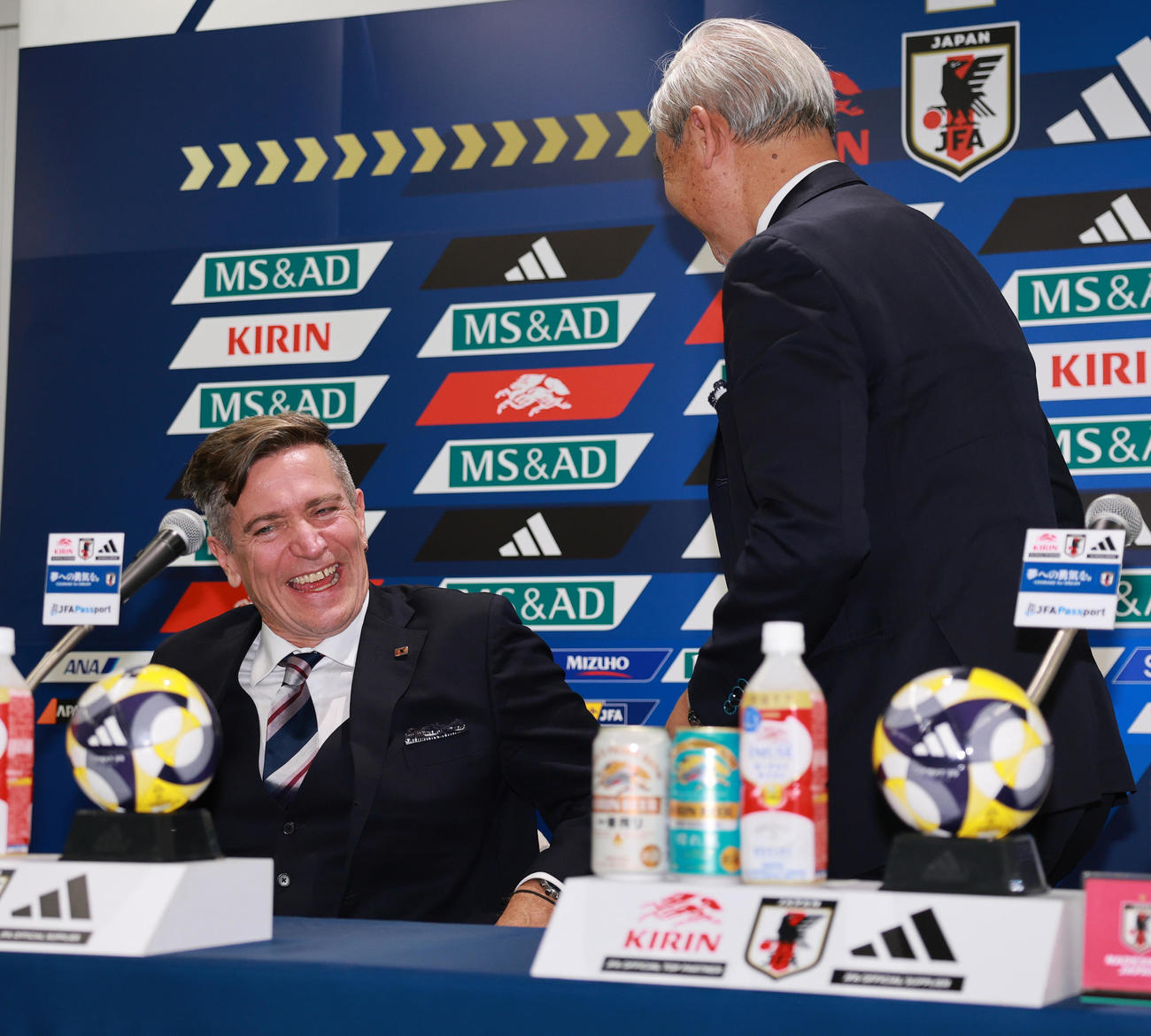 会見を終えたサッカー女子日本代表ニールセン監督（左）は、佐々木女子委員長からねぎらわれ笑顔をみせる（撮影・野上伸悟）