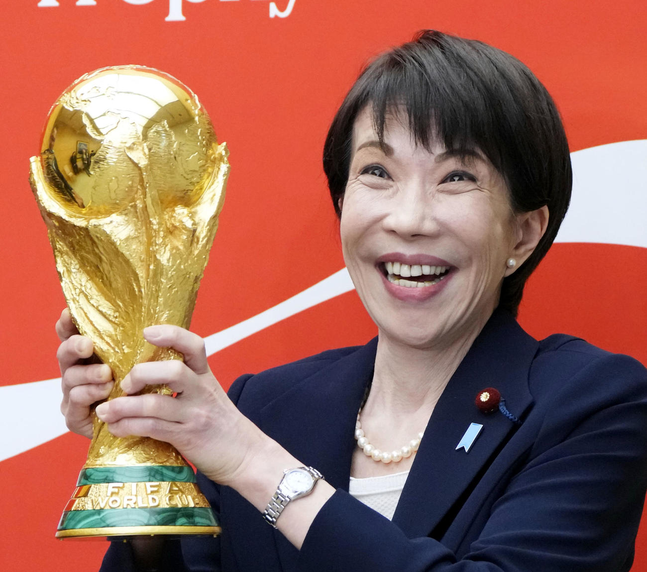 サッカーW杯の優勝トロフィーを持ち、写真撮影する高市首相（共同）