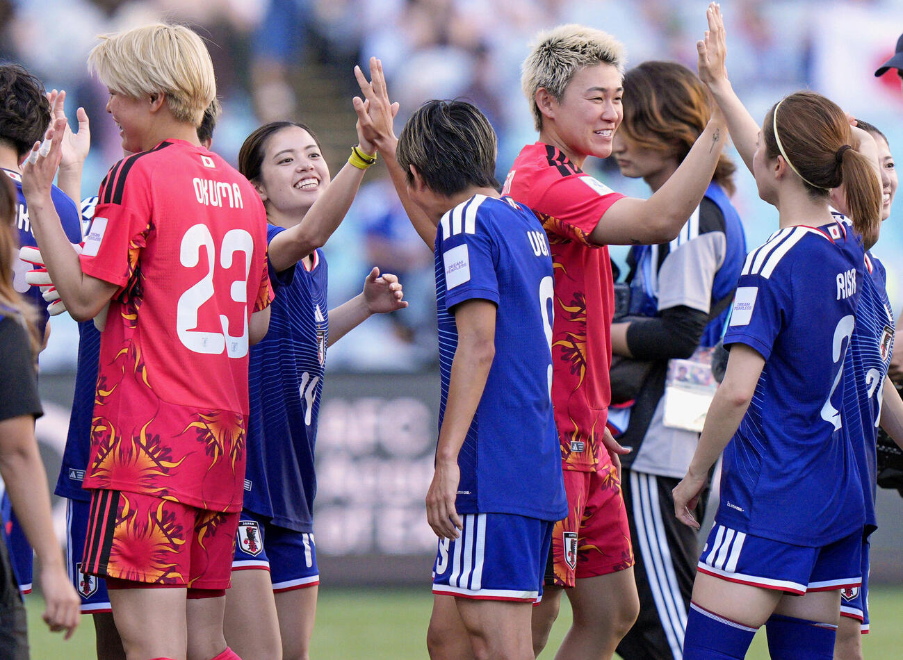 15日、フィリピンに快勝し、タッチを交わす長谷川（左奥）ら女子日本代表。10大会連続10度目のW杯出場を決めた＝シドニー（共同）