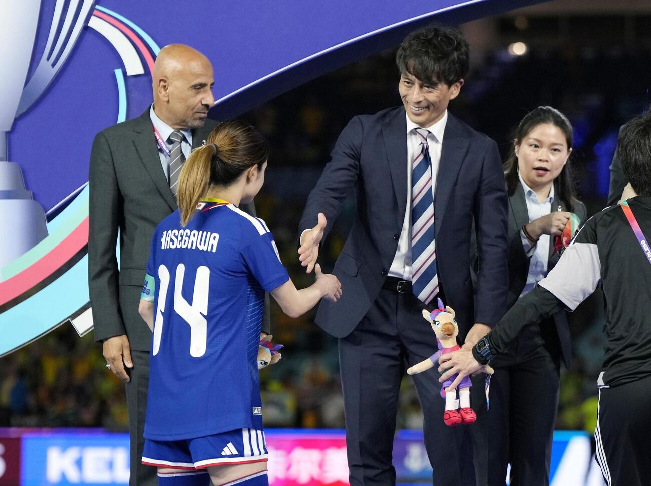 表彰式で長谷川（14）を祝福する日本サッカー協会の宮本恒靖会長＝シドニー（共同）