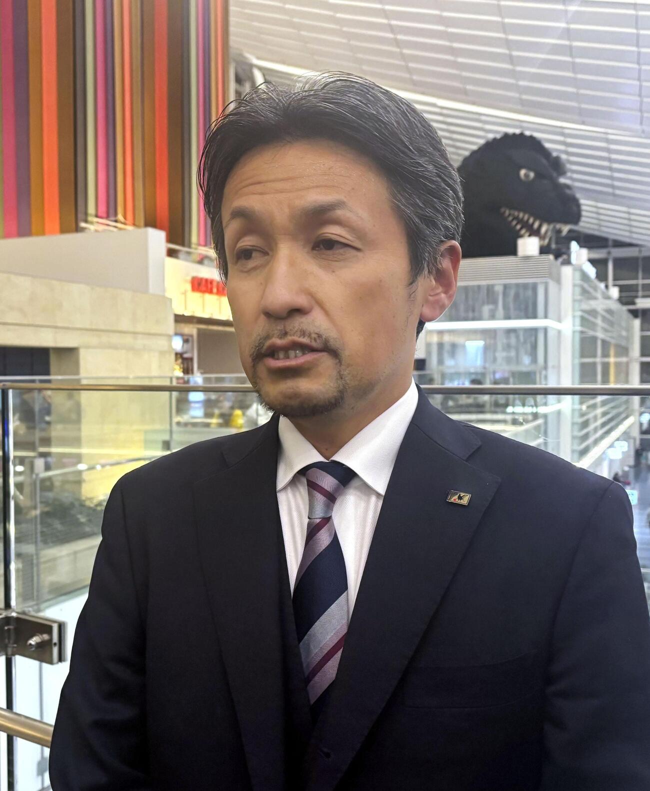 サッカー女子日本代表「なでしこジャパン」の米国遠征への出発前に取材に応じる、狩野倫久監督代行＝7日、羽田空港（共同）