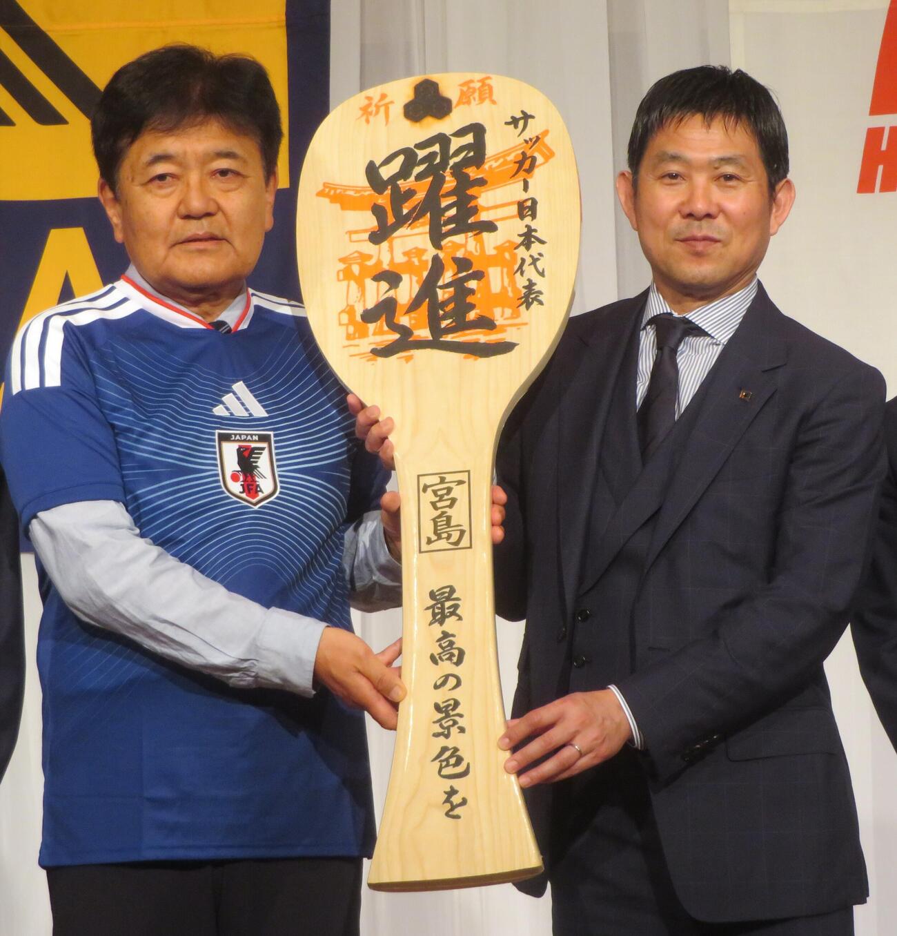 広島県サッカー協会の宗政潤一郎会長（左）からしゃもじを受け取る日本代表の森保一監督