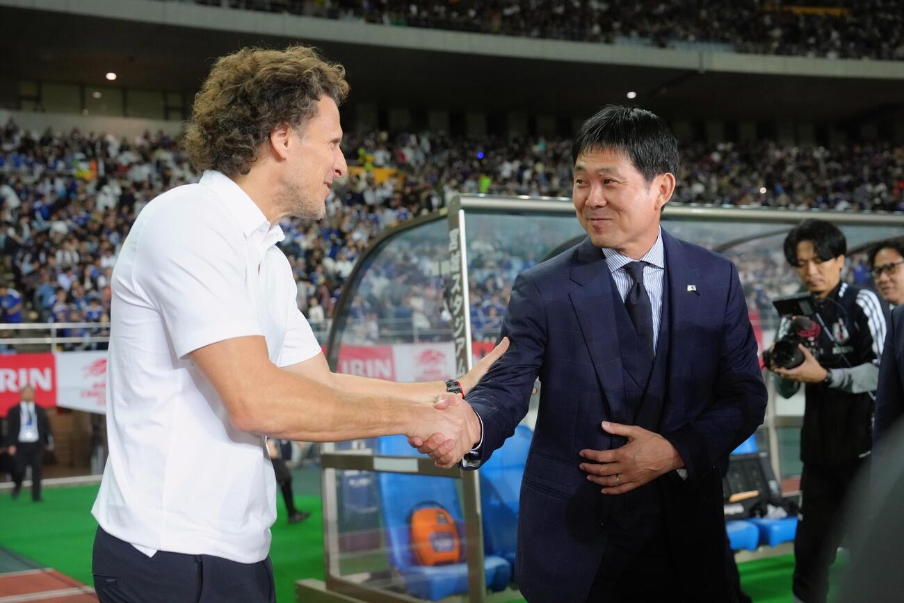 日本対ウルグアイ　試合前に握手を交わすウルグアイのフォルラン監督（左）と森保一監督（撮影・足立雅史）