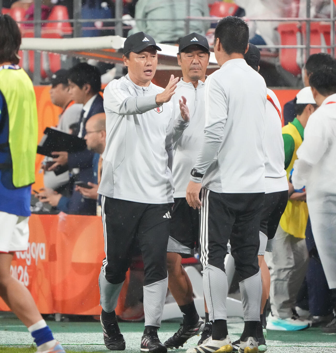 サッカー男子日本対北朝鮮　試合終了、日本大岩剛監督（左）はスタッフとタッチを交わす（撮影・森本幸一）