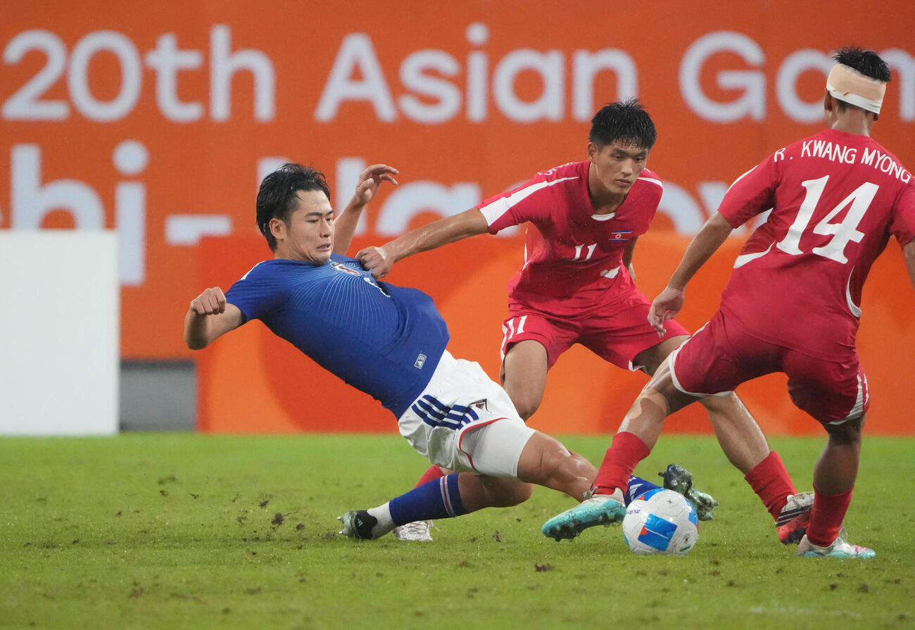 サッカー男子日本対北朝鮮　後半、日本市原吏音（左）は競り合いボールを追う（撮影・森本幸一）