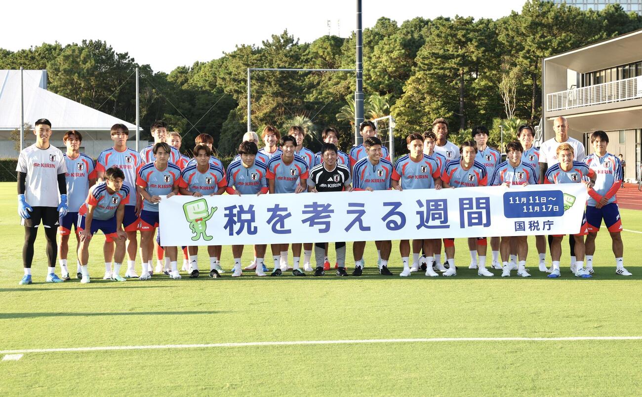 練習前、国税庁のバナーを手に記念撮影に納まる日本代表の選手たち（撮影・宮地輝）
