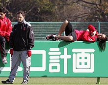 オジェック監督と看板の上に寝転がる闘莉王