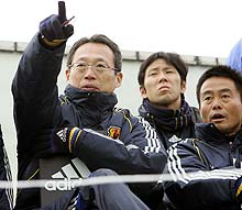 岡田監督（左）は大木コーチ（右）とスタンドから練習試合を見つめる