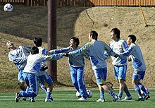 手をつなぎ明るい表情でへディング練習をする選手ら（撮影・宇治久裕）
