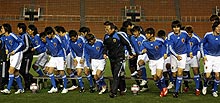 寒い中での集合写真撮影が終わり、足早に引き揚げる岡田監督（中央）と選手