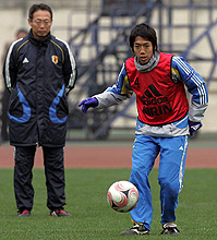 パスを出すＭＦ中村。左は岡田監督（撮影・蔦林史峰）
