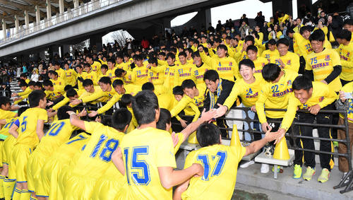 勝利後、スタンドから応援したベンチ外メンバーと懸命に手を伸ばしハイタッチを交わす立正大淞南イレブン（撮影・鈴木みどり）