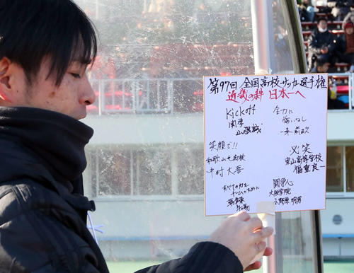 試合前、「近畿の絆　日本一へ」と題した近畿ブロック6府県の各監督の言葉が記された色紙をベンチに張る和歌山北のスタッフ（撮影・狩俣裕三）