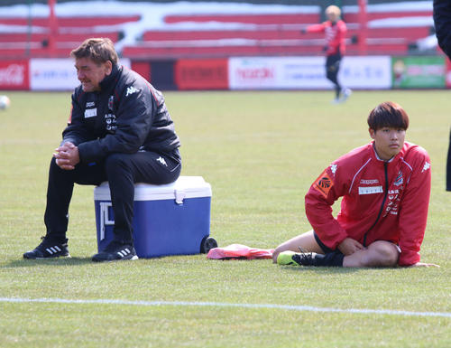 練習後にストレッチするコンサドーレ札幌FW岩崎（右）。左はペトロビッチ監督（撮影・保坂果那）