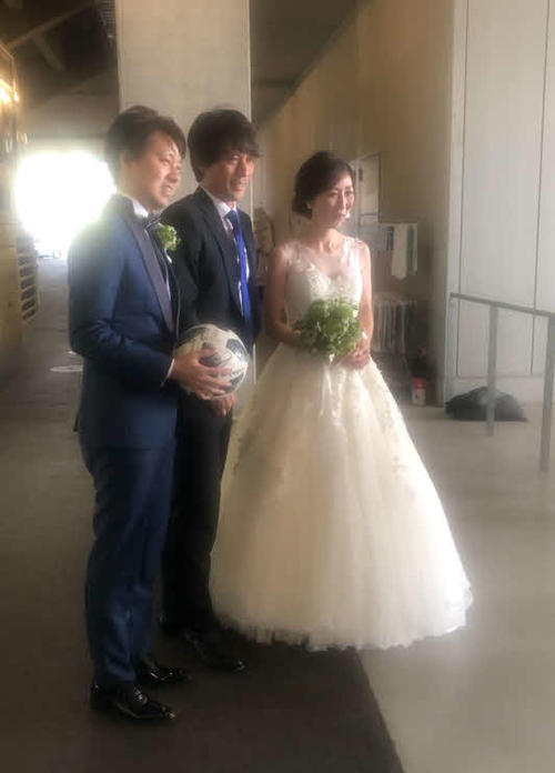 敵地広島へ出発前に新郎新婦と写真に納まるG大阪宮本恒靖監督（撮影・小杉舞）