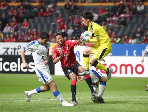 札幌対大分　前半、ゴール前に上がったボールをGK高木に阻まれる札幌FW鈴木（左から2人目）（撮影・黒川智章）