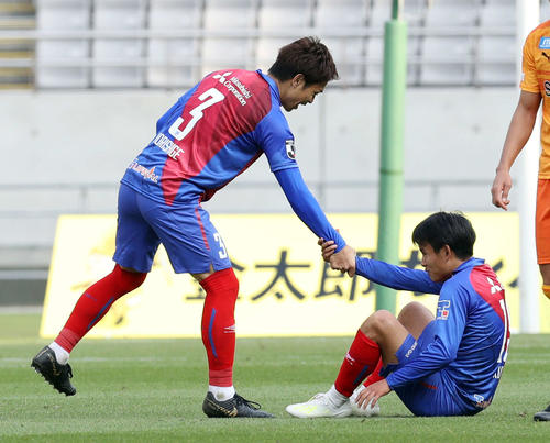 試合終了でピッチに座り込んだ東京MF久保（右）は、DF森重の手を借りて立ち上がる（撮影・河野匠）