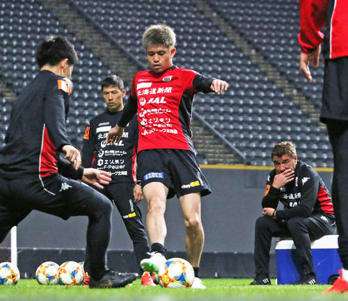 ボール回しに参加する札幌DF進藤。右奥は見守るペトロビッチ監督（撮影・保坂果那）