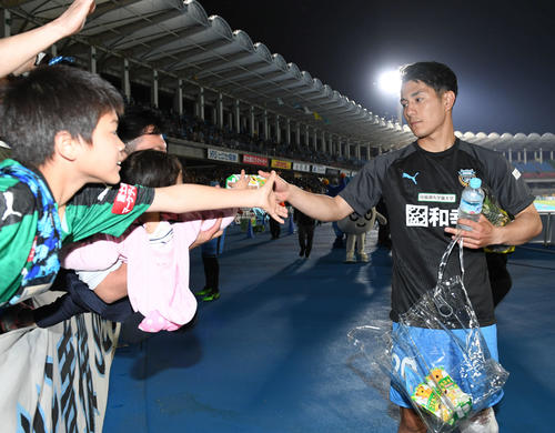 川崎F対湘南　4試合連続ゴールの川崎F・FW知念は子どもたちにお菓子を配る（撮影・山崎安昭）