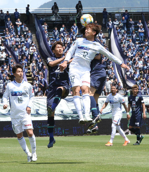 福岡対山形　激しく競りあう福岡DF実藤友紀（撮影・菊川光一）