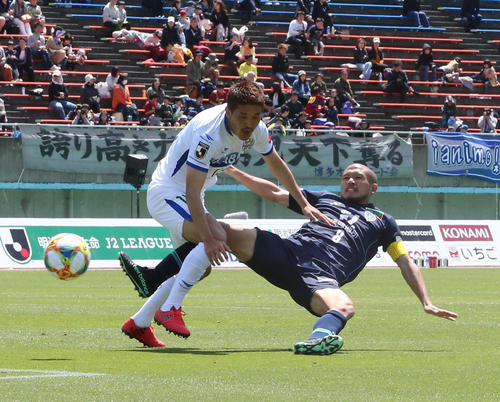 福岡対山形　激しい競りあいで倒される福岡MF鈴木惇（右）（撮影・菊川光一）