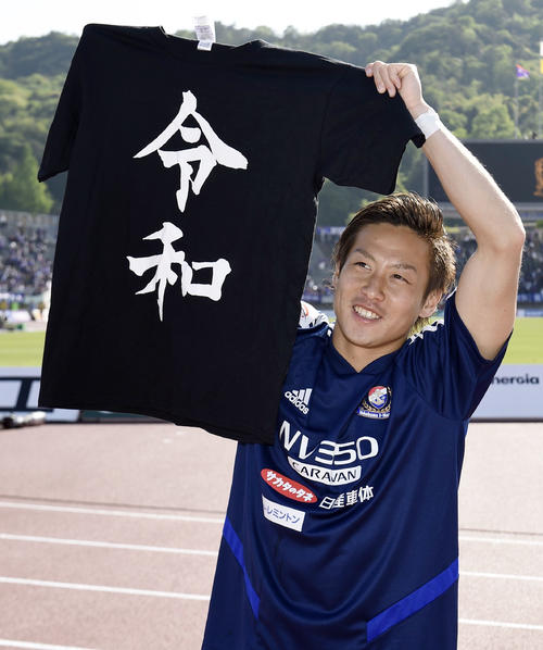 Tシャツを手にサポーターにあいさつする仲川（共同）