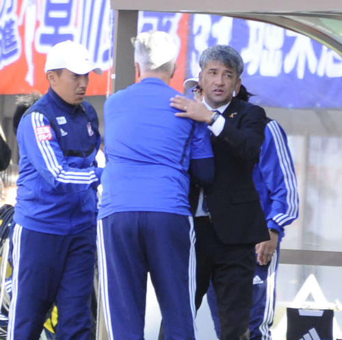 新潟対山口　試合終了直後、スタッフと抱き合い、勝利を喜ぶ吉永監督（右）