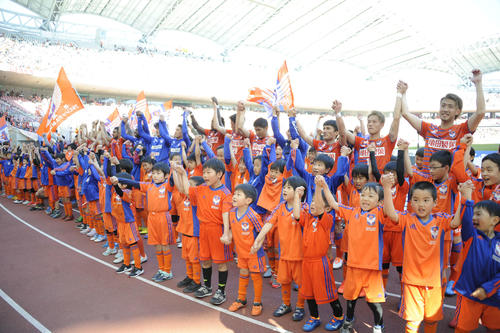 試合後、下部組織の子どもたちとともにバンザイをする新潟のメンバー