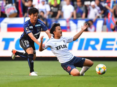 G大阪対東京　前半、G大阪MF高（左）に倒される東京MF久保（撮影・上田博志）