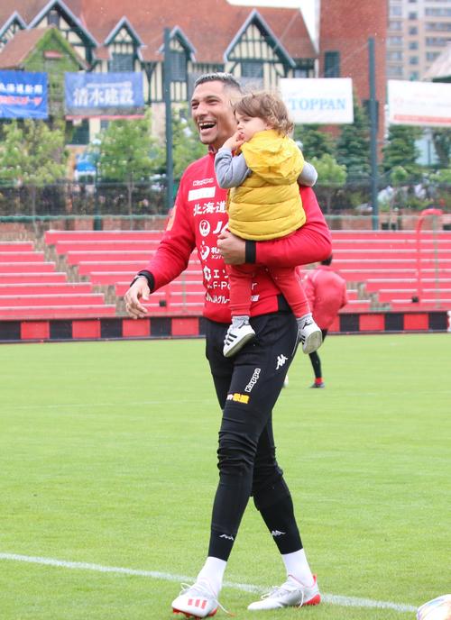 練習後、息子バルサザール君を抱っこしてグラウンドを後にする札幌FWジェイ（撮影・保坂果那）