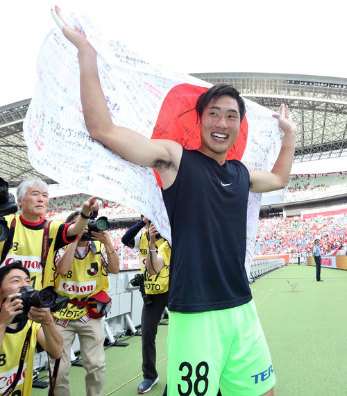 浦和対広島　試合後、サポーターのメッセージが書かれた日の丸を掲げ、笑顔を見せる広島GK大迫（撮影・狩俣裕三）