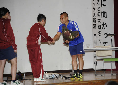 生徒から花束を贈呈され、笑顔を見せる早川（右）