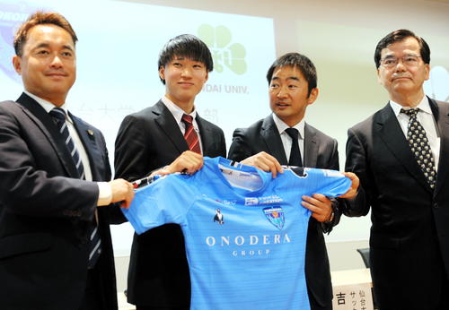 J2横浜FCに入団内定した仙台大MF松尾（左から2人目）はユニホームを手に、服部GM（左）、吉井監督（同3番目）、遠藤学長（右）に囲まれ、飛躍を誓う