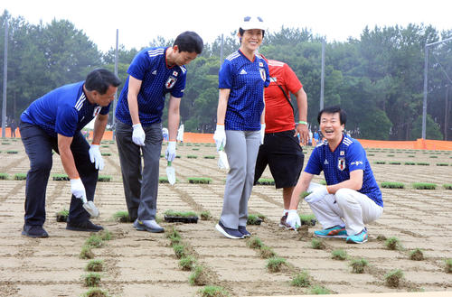JFA夢フィールドでのポット苗植え付けイベントで苗植えしながら笑顔で喜ぶ高円宮妃久子様（右から2人目）。右は森田健作千葉県知事。左から田嶋会長、熊谷俊人千葉市長（撮影・浅見桂子）