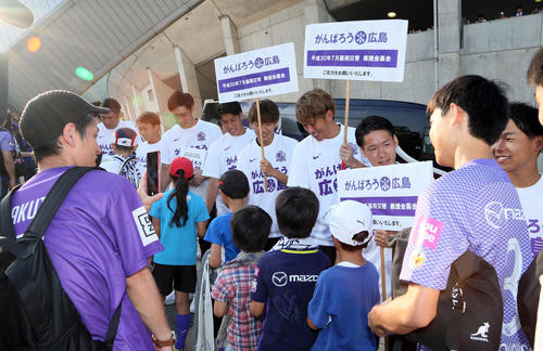試合前、「がんばろう広島」のボードを掲げ募金活動をする選手ら（撮影・栗木一考）