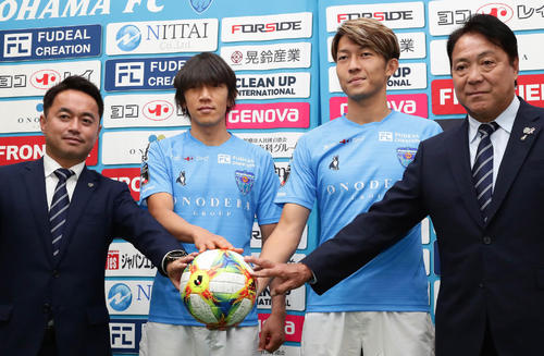 ボールに手を添えて写真に納まる、左から服部GM、中村俊、皆川、奥寺会長（撮影・丹羽敏通）