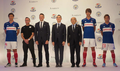 発表会に出席した、左から横浜のDF畠中、マンチェスター・CのOBのポール・ディコフ氏、CFGのアジア・パシフィック地域パートナーシップ部門のステファン・シープリック本部長、メルコリゾーツ＆エンターテインメントのローレンス・ホーCEO、横浜の黒沢社長、横浜のMF扇原、FW仲川（撮影・松尾幸之介）