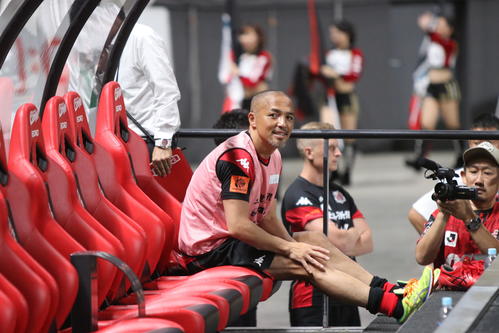 札幌対浦和　試合前、ベンチに座り笑顔を見せる札幌MF小野（撮影・西塚祐司）