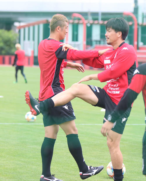 横山と肩を組み合い足を伸ばすMF早坂（撮影・西塚祐司）