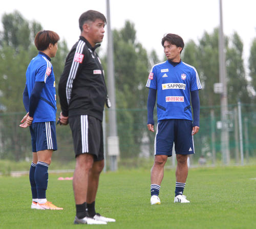 練習前に集合したMF小川（右）はMFチョ・ヨンチョル（左）と会話をかわす。中央は吉永監督