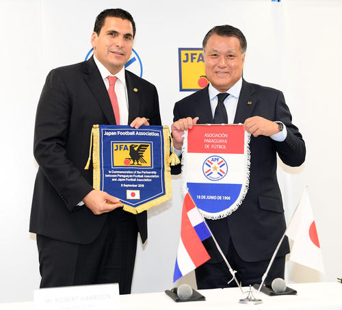 パラグアイとパートナーシップ協定を結び、笑顔を見せる田嶋幸三日本サッカー協会会長（右）とロベルト・ハリソンパラグアイサッカー協会会長（撮影・たえ見朱実）