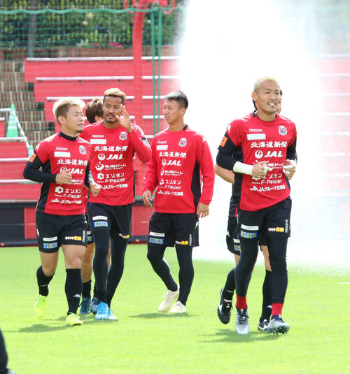 札幌の練習に合流した日本代表FW鈴木（左から2人目）はスタンド席のサポーターの声援に応える（撮影・保坂果那）