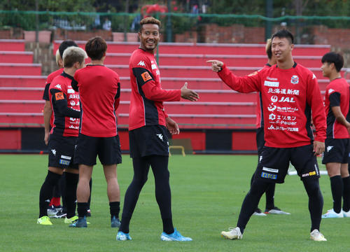 札幌の練習に合流した日本代表FW鈴木（手前左）は振り向き笑顔を見せる。手前右はMF荒野（撮影・保坂果那）